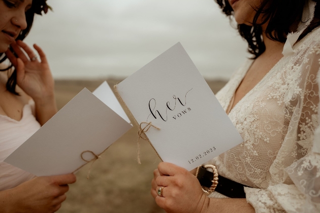 two bride holding booklets with vows written on
