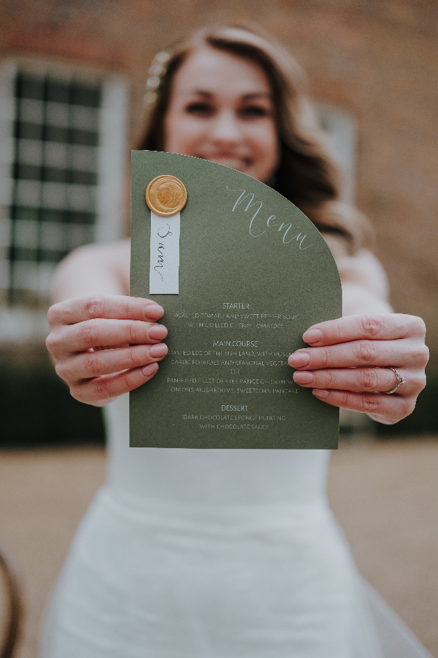 bride holding green invitation