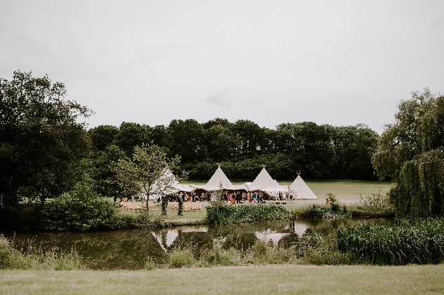 View of a wedding tipi across the pond at Maplehurst Farm