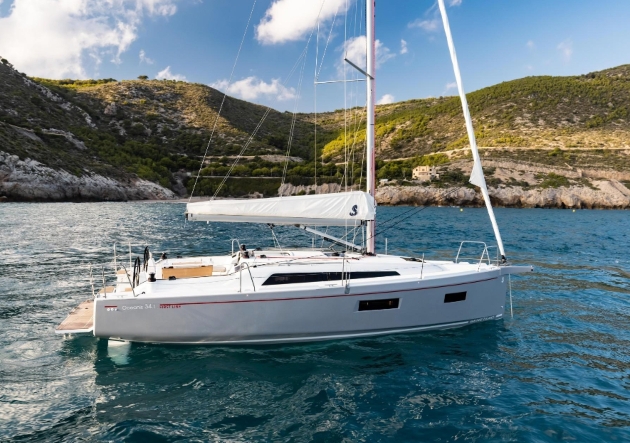 A white boat sailing in front of green hills