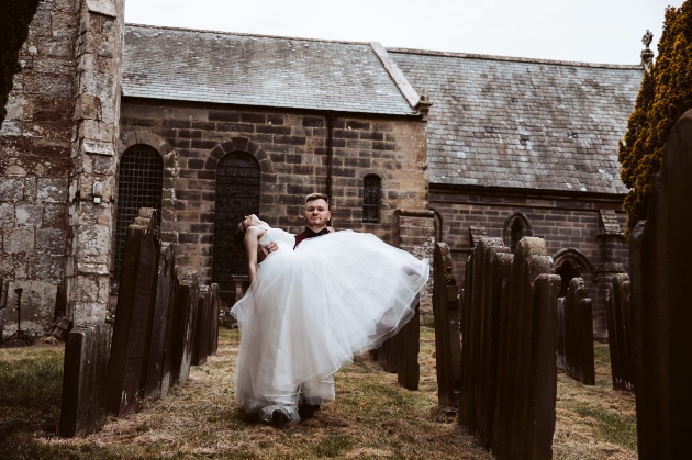 Groom carrying his dead-looking bride from the church Halloween themed wedding