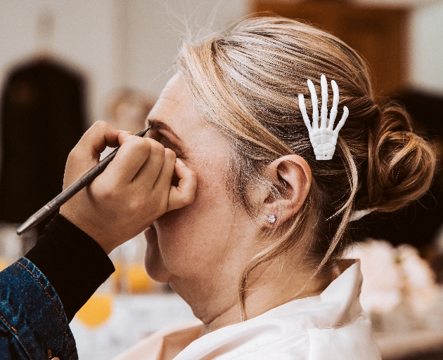 Halloween themed bride having her makeup done wearing a skeletal hand hair clip