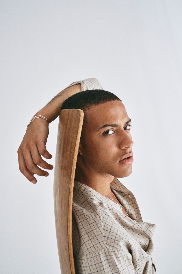 A man sitting on a chair wearing a silver bracelet