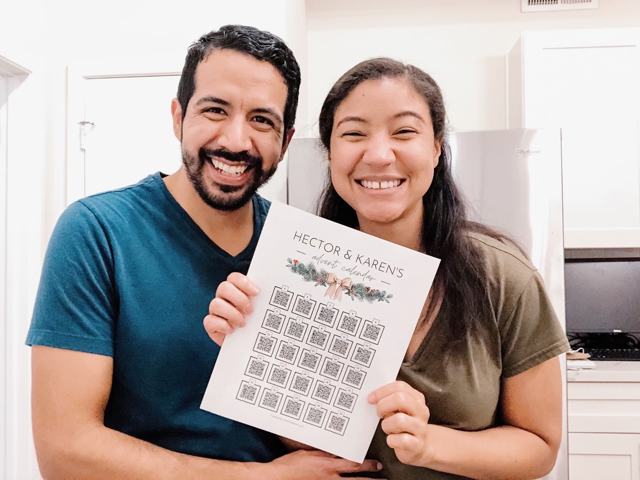 couple standing in their kitchen holding an advent calendar 