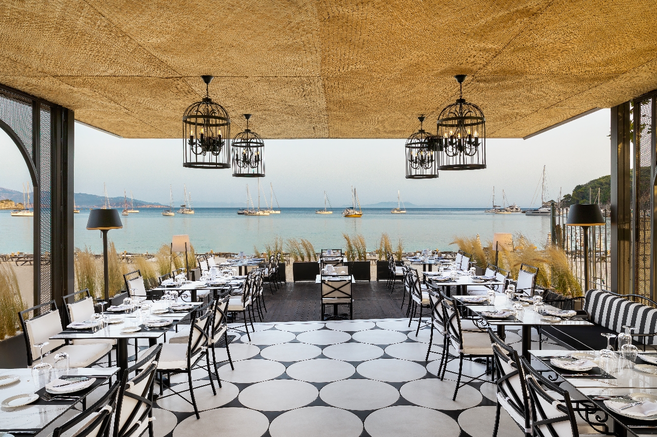 black metal chairs on a deck under a canopy al fresco with sea views