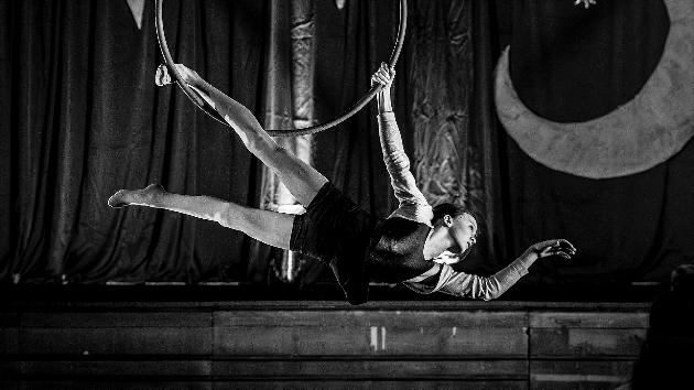 Acrobat hanging from aeria loop - Inertia