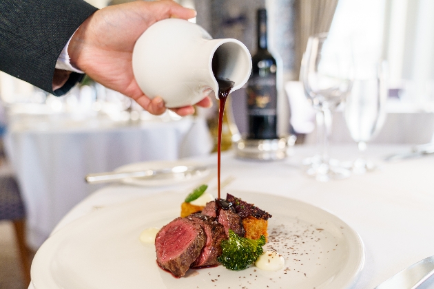 sauce pouring onto fine dining meat dish at The Grand Eastbourne