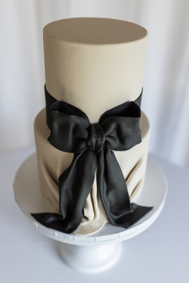 white three-tier wedding cake with black bow