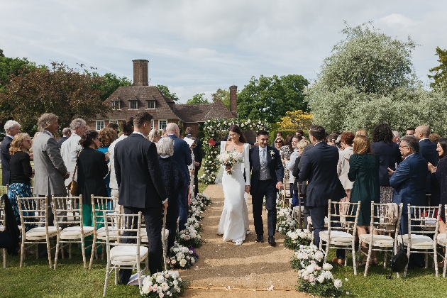 bride and groom walking down the aisle after their ceremony - outdoor wedding