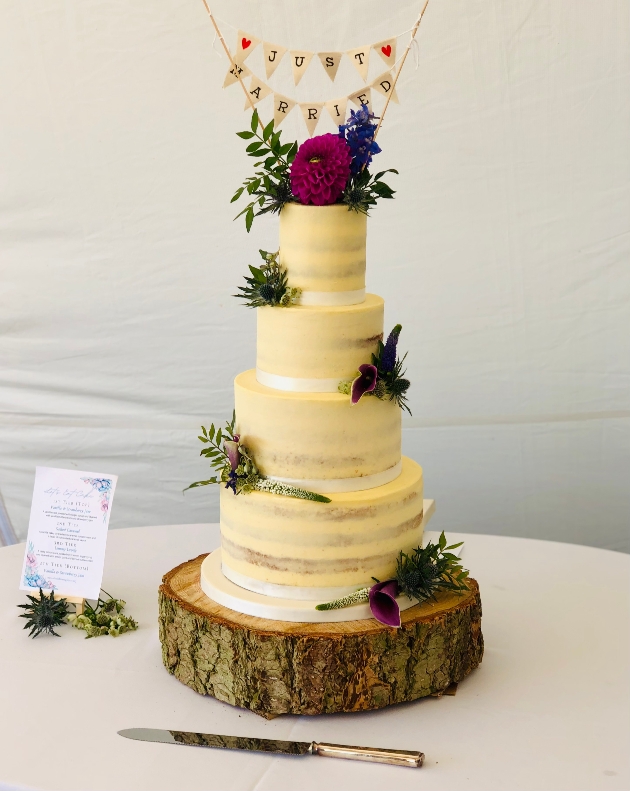 four tier semi-naked wedding cake on log slice, by A Little Bit Naughty
