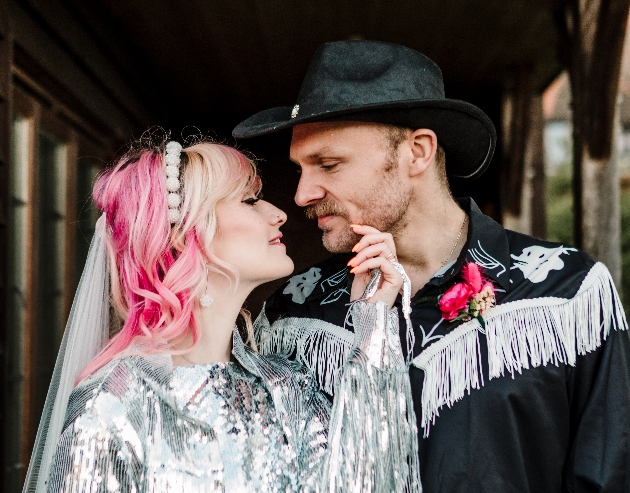 bride and groom - bride with pink hair and sparkly silver jacket, groom with black cowboy hat and fringed shirt