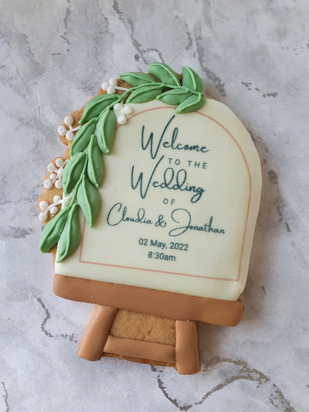 wedding cookie shaped like a welcome sign with couple's names and wedding date