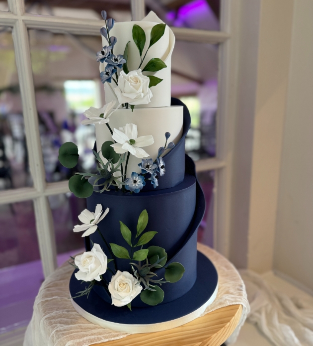 navy and white iced wedding cake with sugar flowers