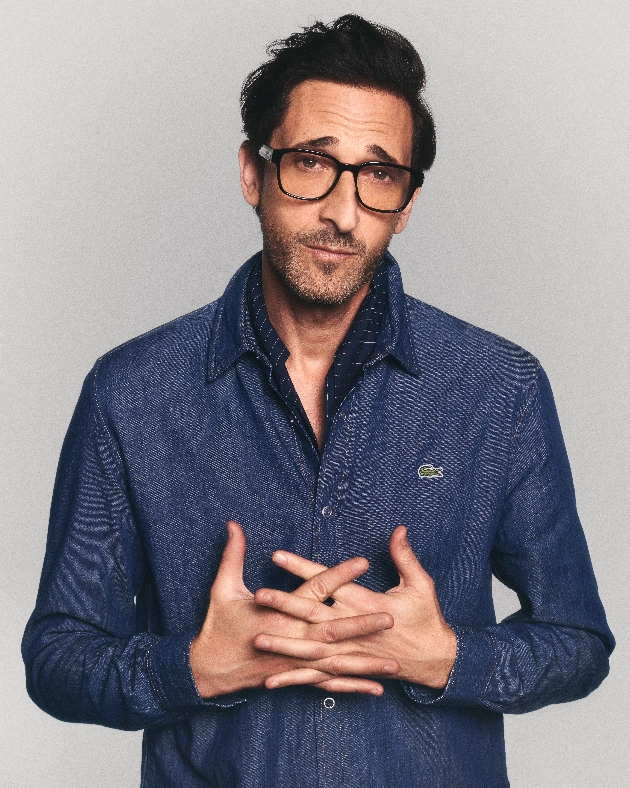 Adrien Brody wearing glasses looking at the camera